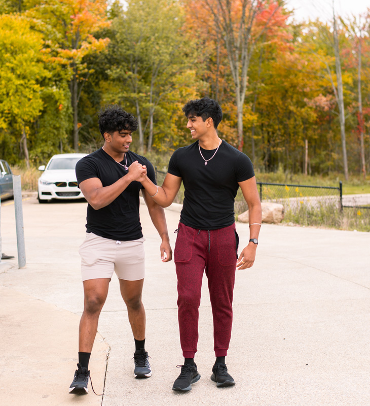 Coachs walking outdoors and holding each others hands.